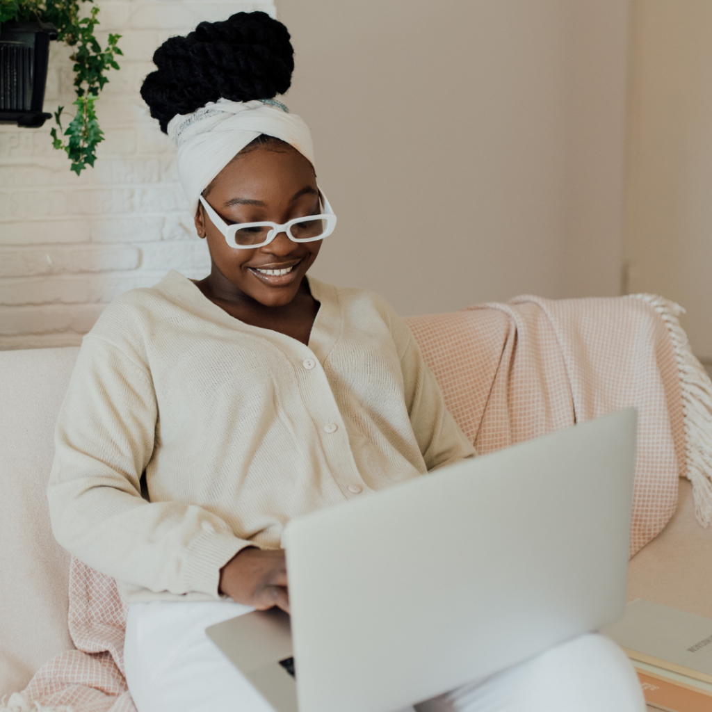 Black Woman on computer, smiling and working