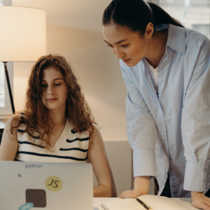 Two business women looking at computer white and Asian 